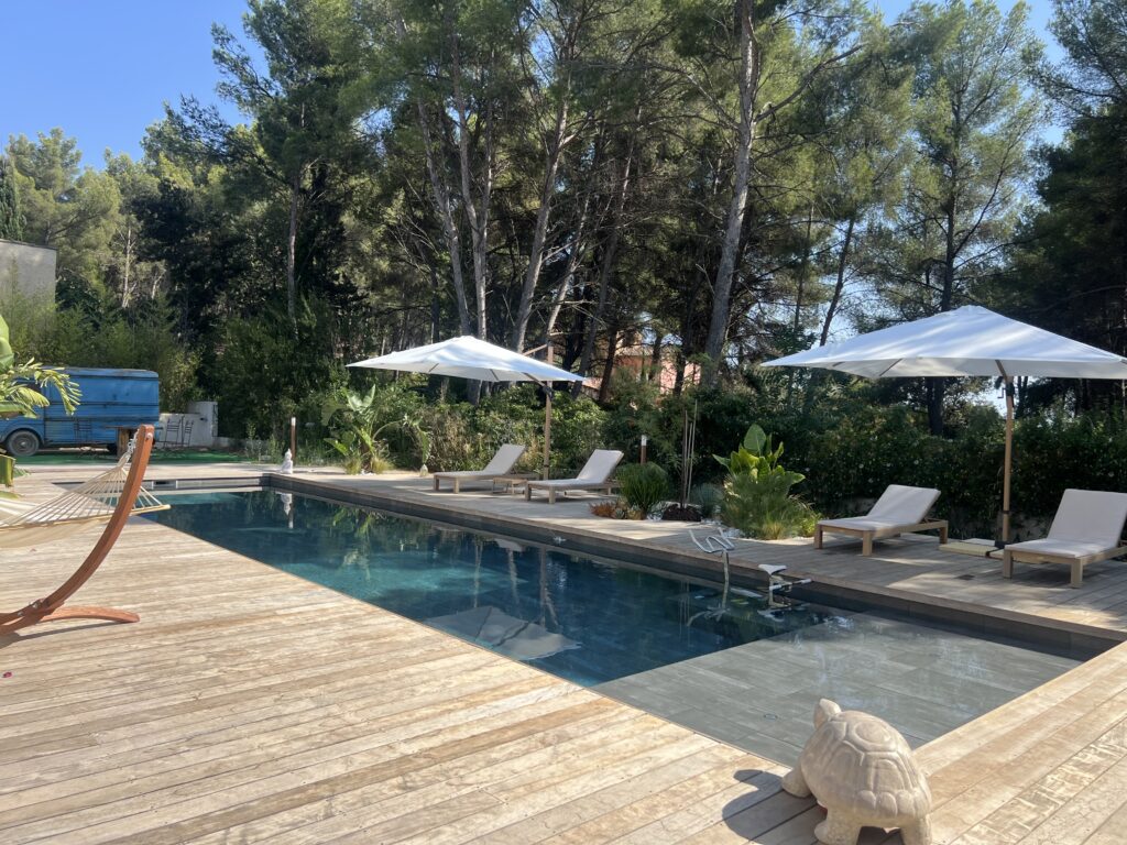 Piscine entourée d'arbres et chaises. Pandora Suite Sanary